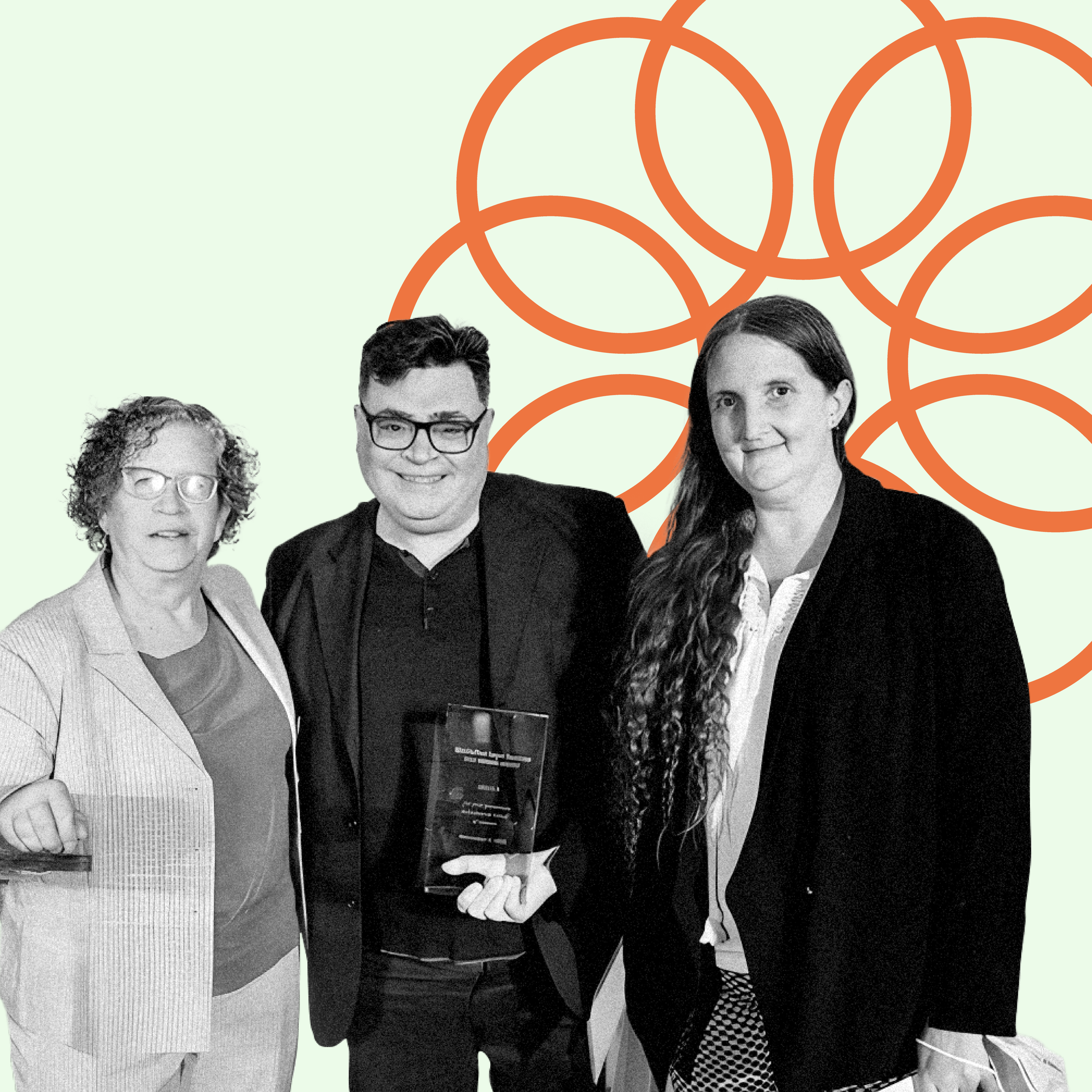 Three organizers posing for a photograph holding an award between them. Light green background with an orange spiral graphic made up of concentric circles behind them.