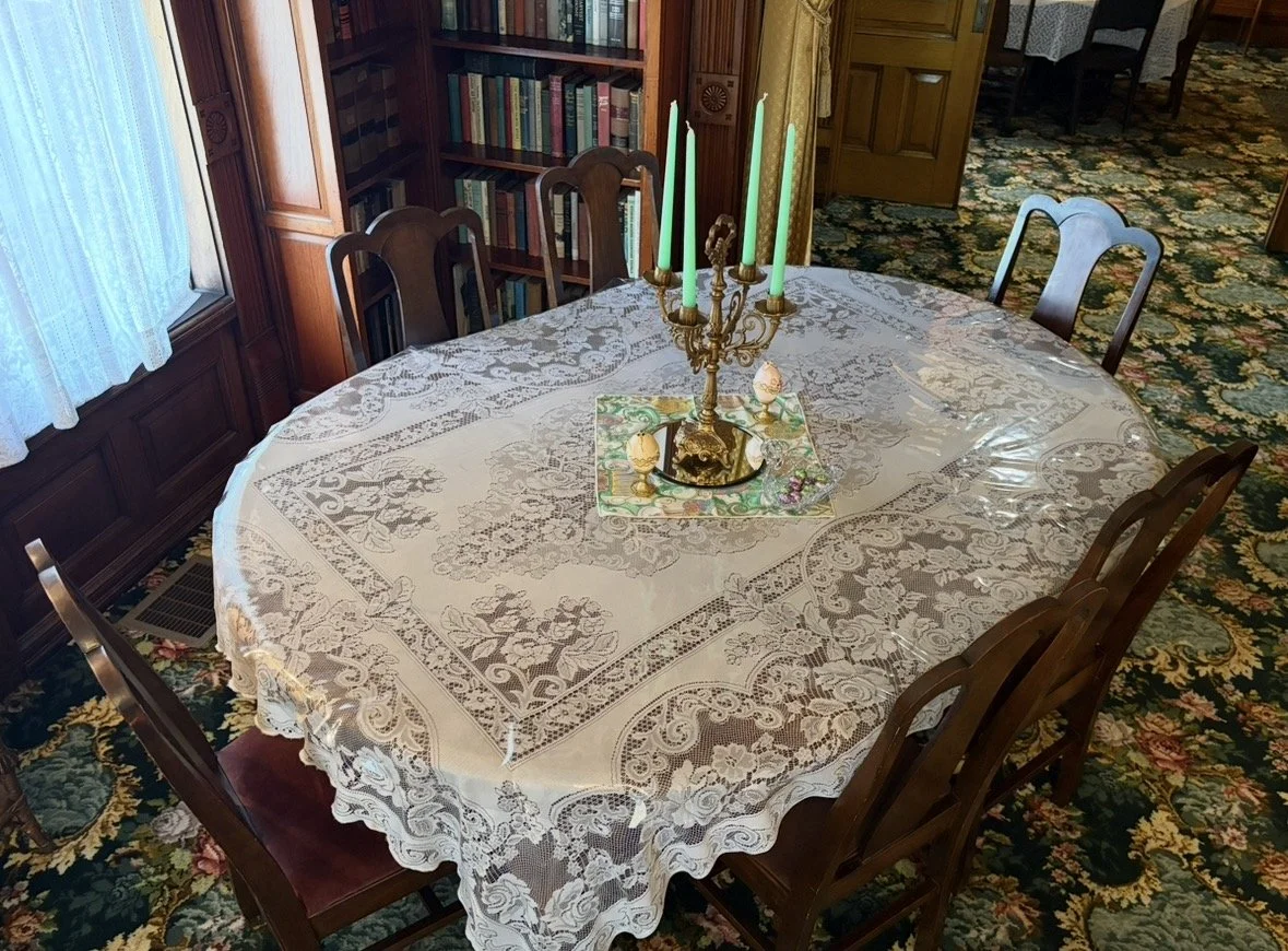 A table with a fancy lace tablecloth and candles