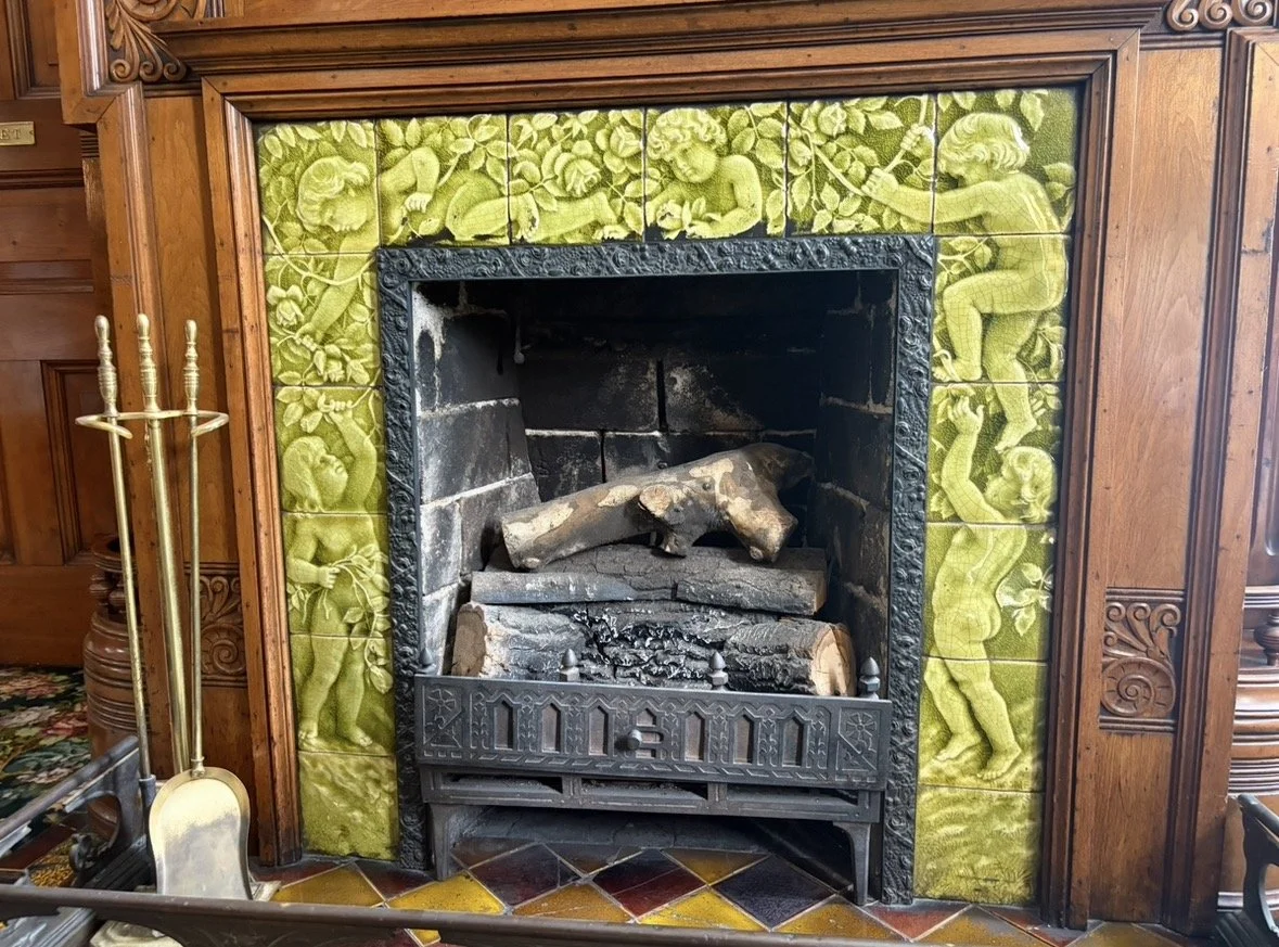 A decorative fireplace with green tiles