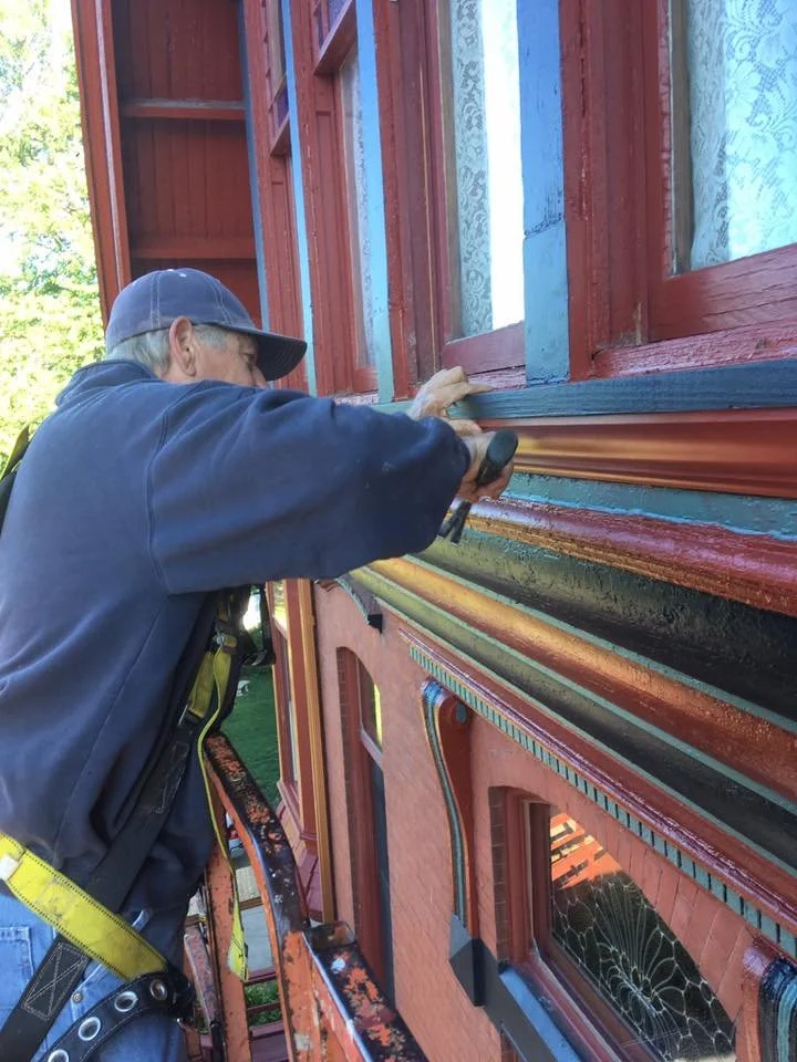 worker repairing some trim around a window