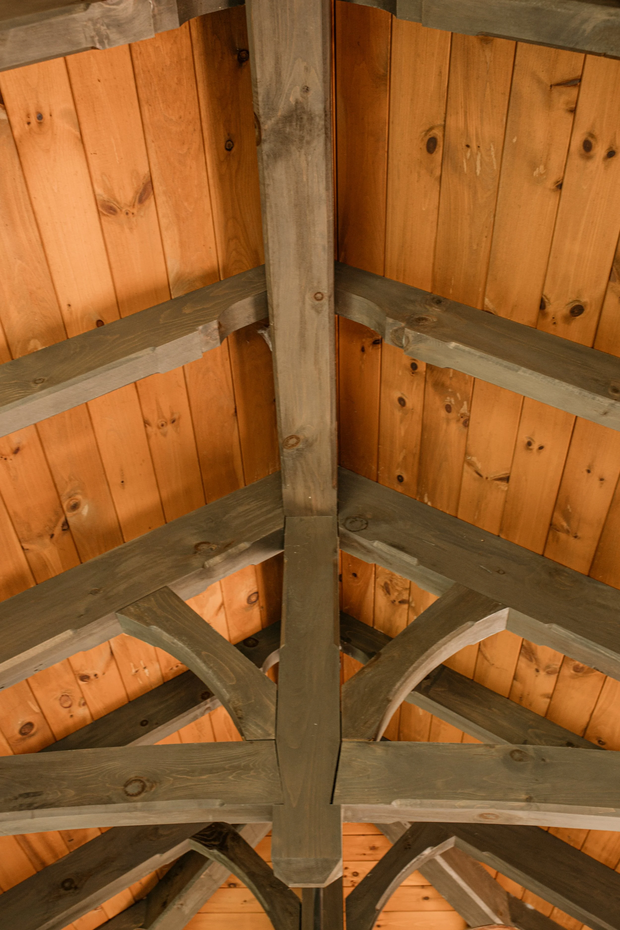 Ceiling with wooden beams and paneling in a rustic style.