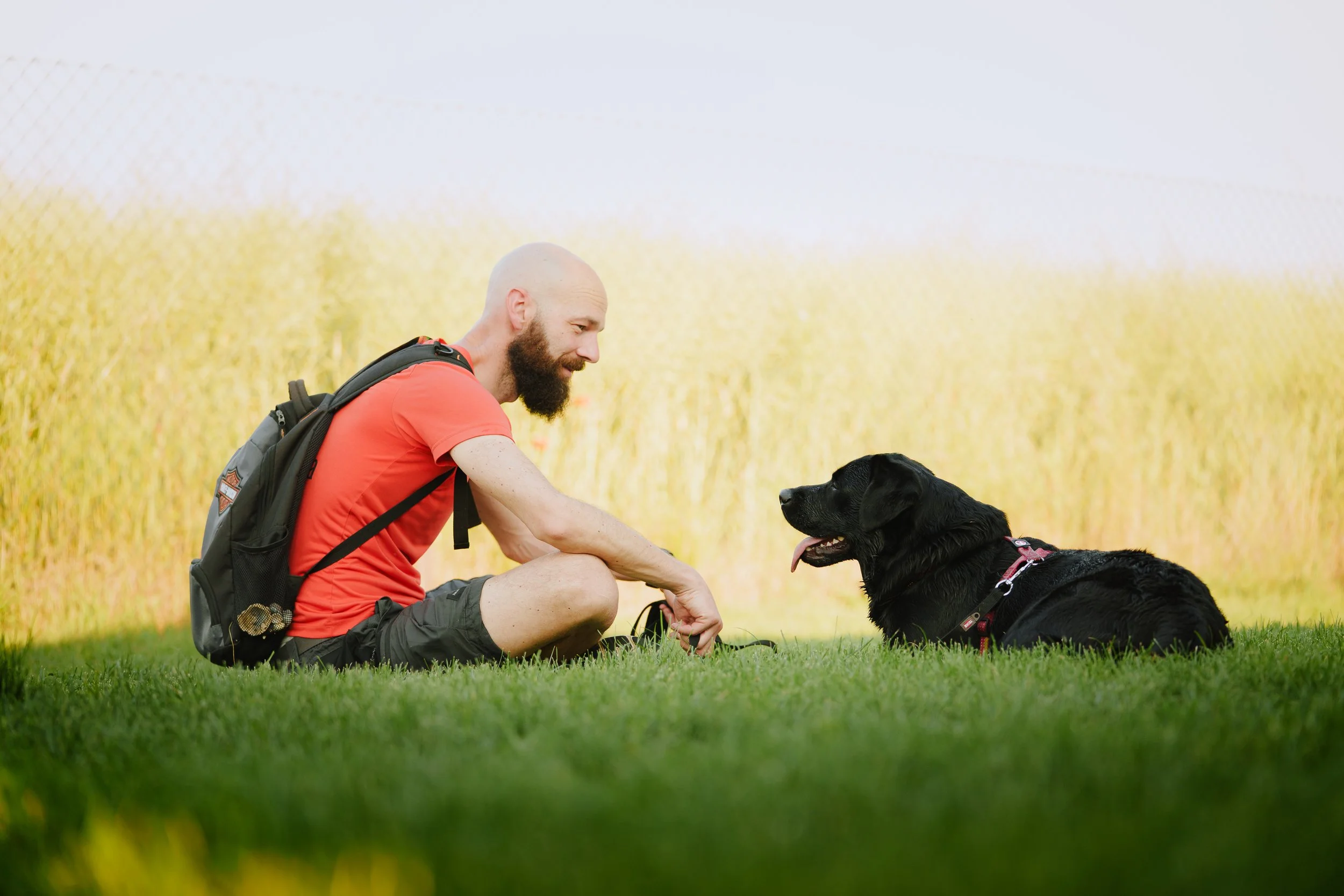 Un uomo e un cane che si guardano da sdraiati per terra