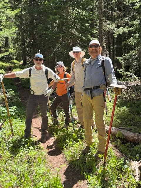 Trail crew volunteers for Rico Trails Alliance standing on a forest trail near the Colorado Trail.