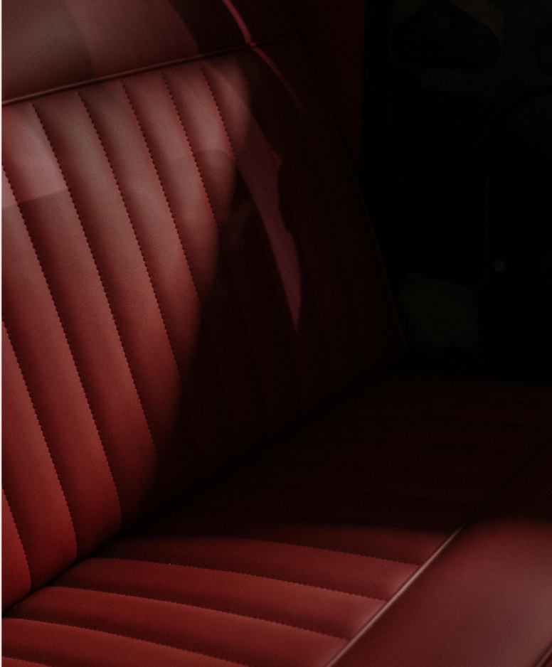 Red leather bench seat with vertical stitching, used as a design element on a modern finance website.