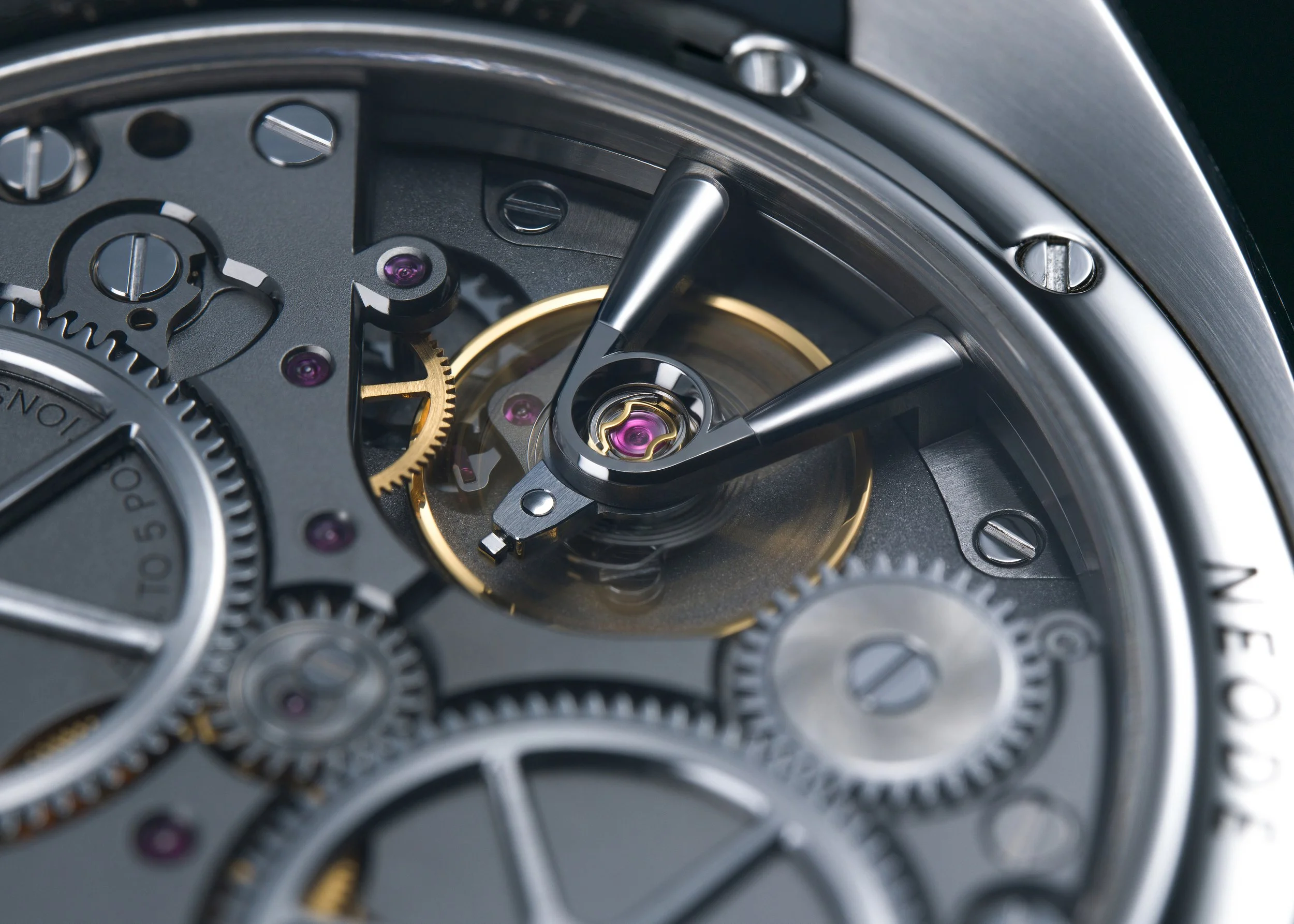 Close-up of watch gears and mechanisms, showing intricate metal parts, screws, and purple jewels inside a watch.