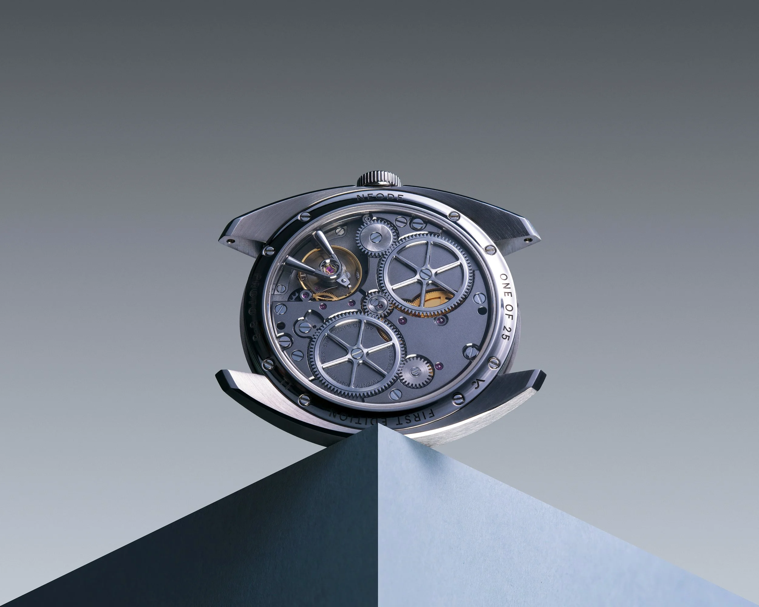 Close-up of a mechanical watch movement with gears and cogs visible, mounted on a stand against a gradient background.