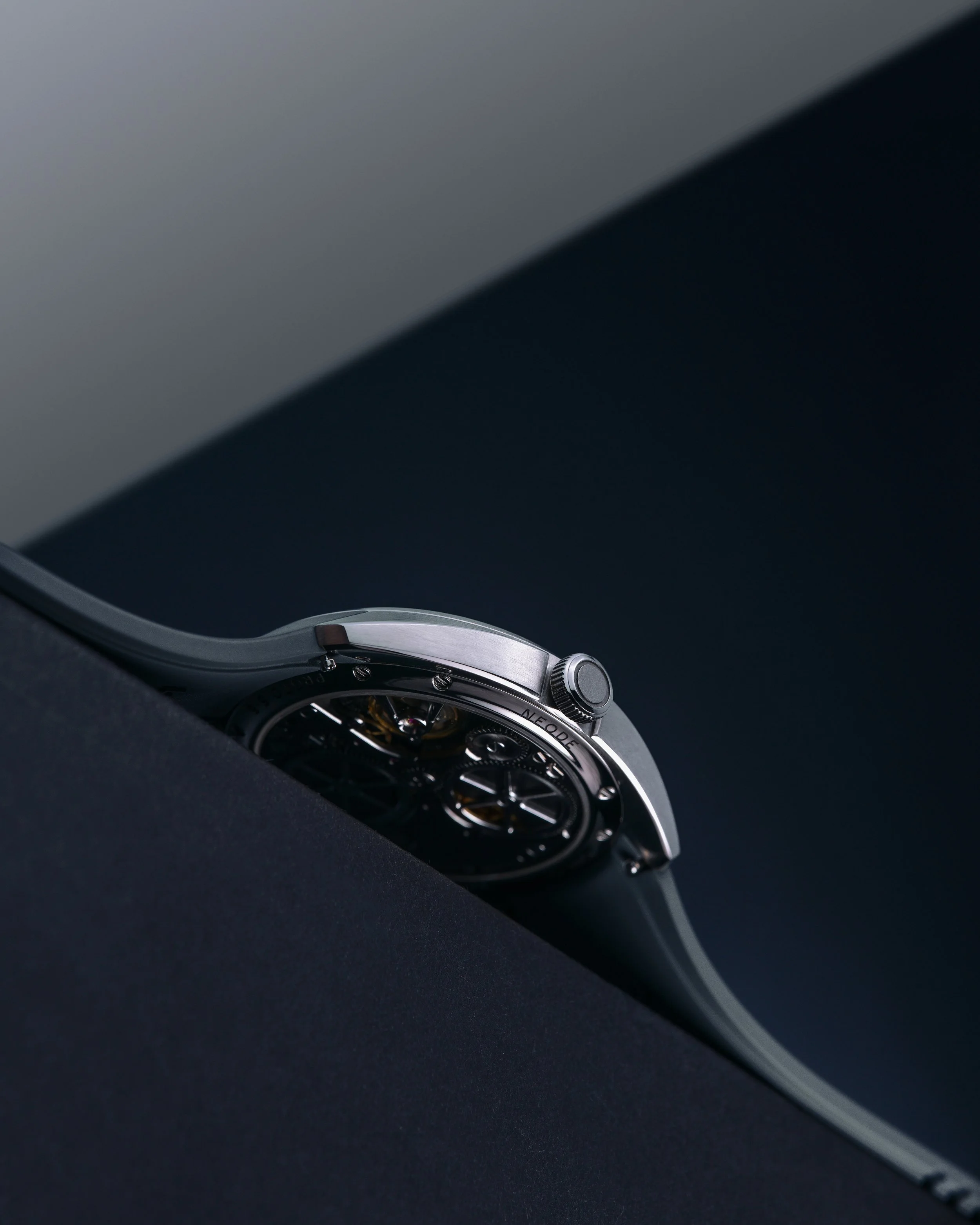 Close-up of the N01 First Edition Pure Silver timepiece with a metallic band, laying on a dark surface.