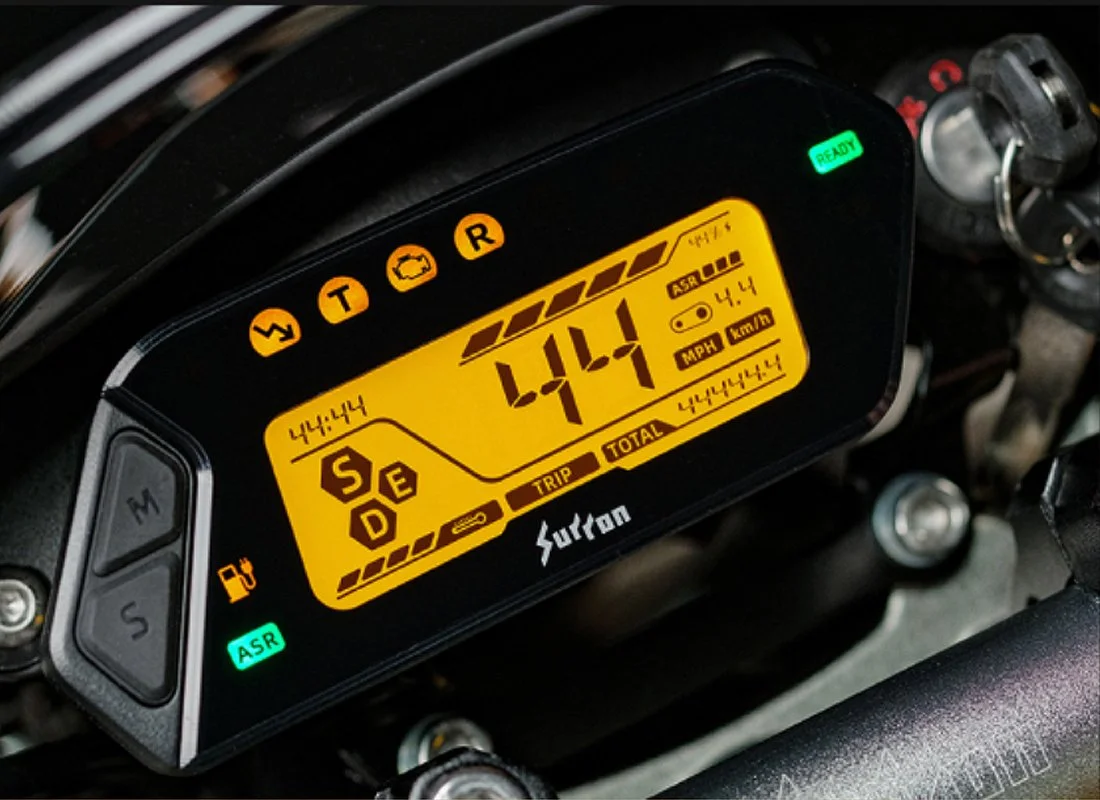 Close-up of a digital motorcycle dashboard displaying a speed of 49.1 miles per hour, various warning lights, and indicators.