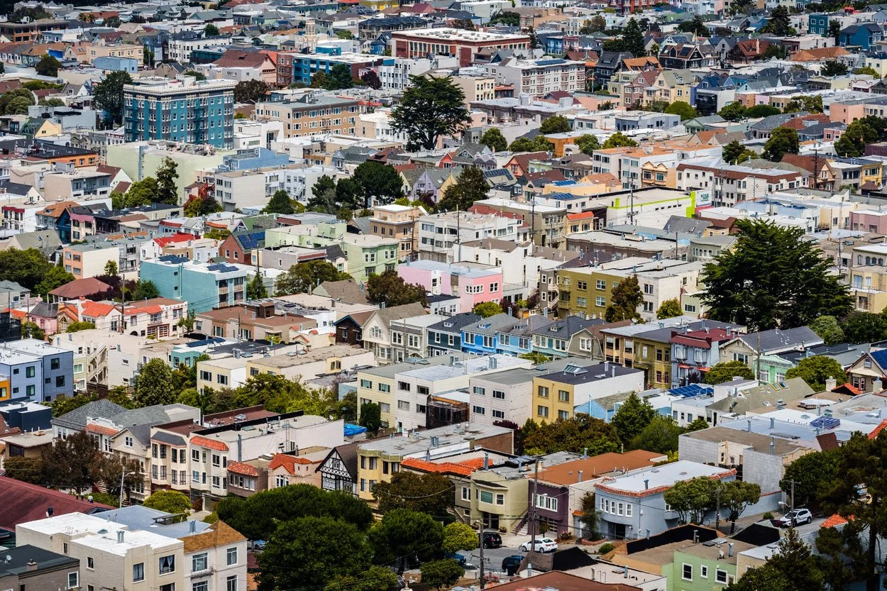 Aerial view of a densely packed neighborhood with colorful houses and trees.