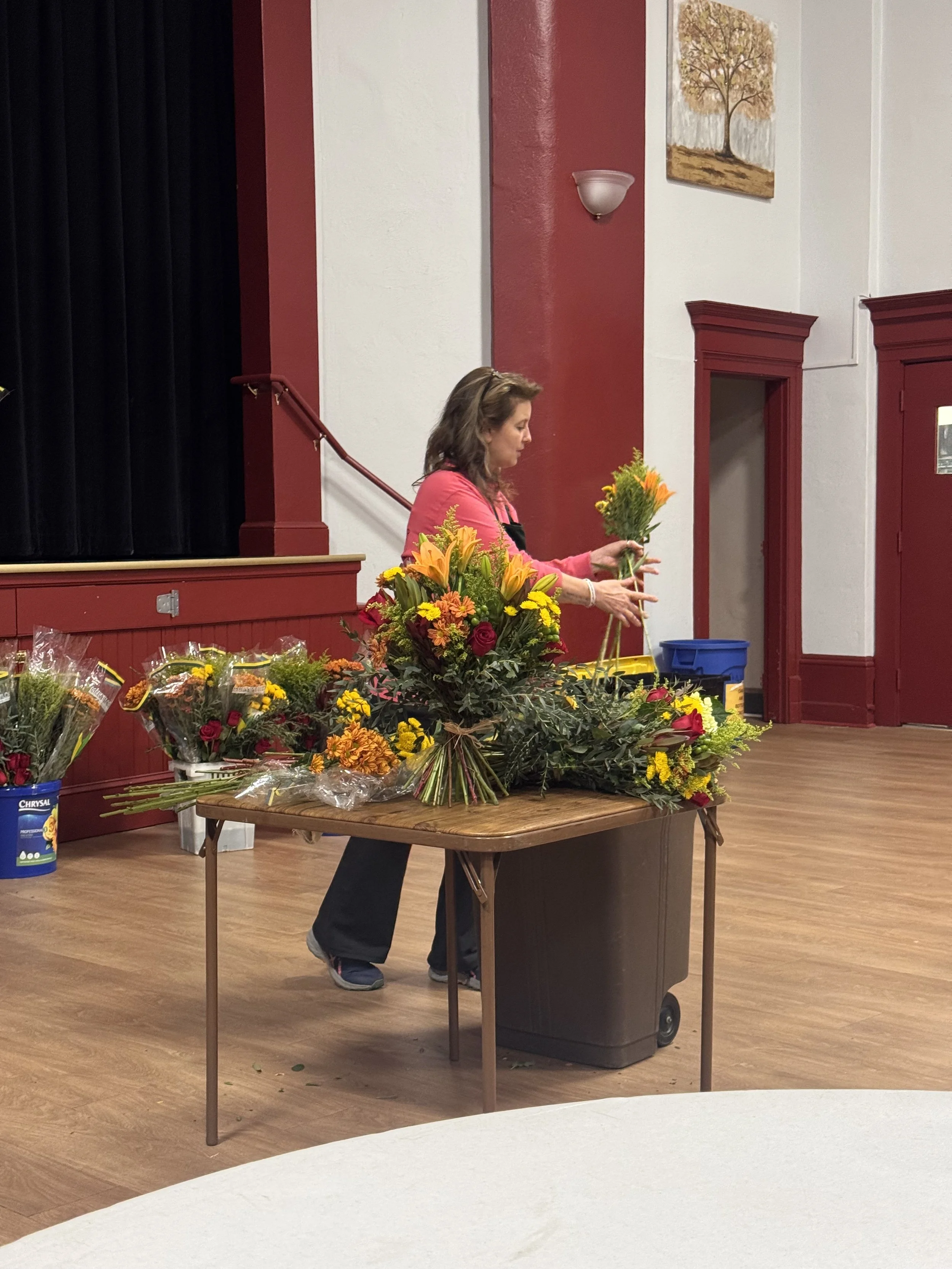 Stephanie Fusco from Terri's Flower Shop demonstrating a bouquet arrangement.