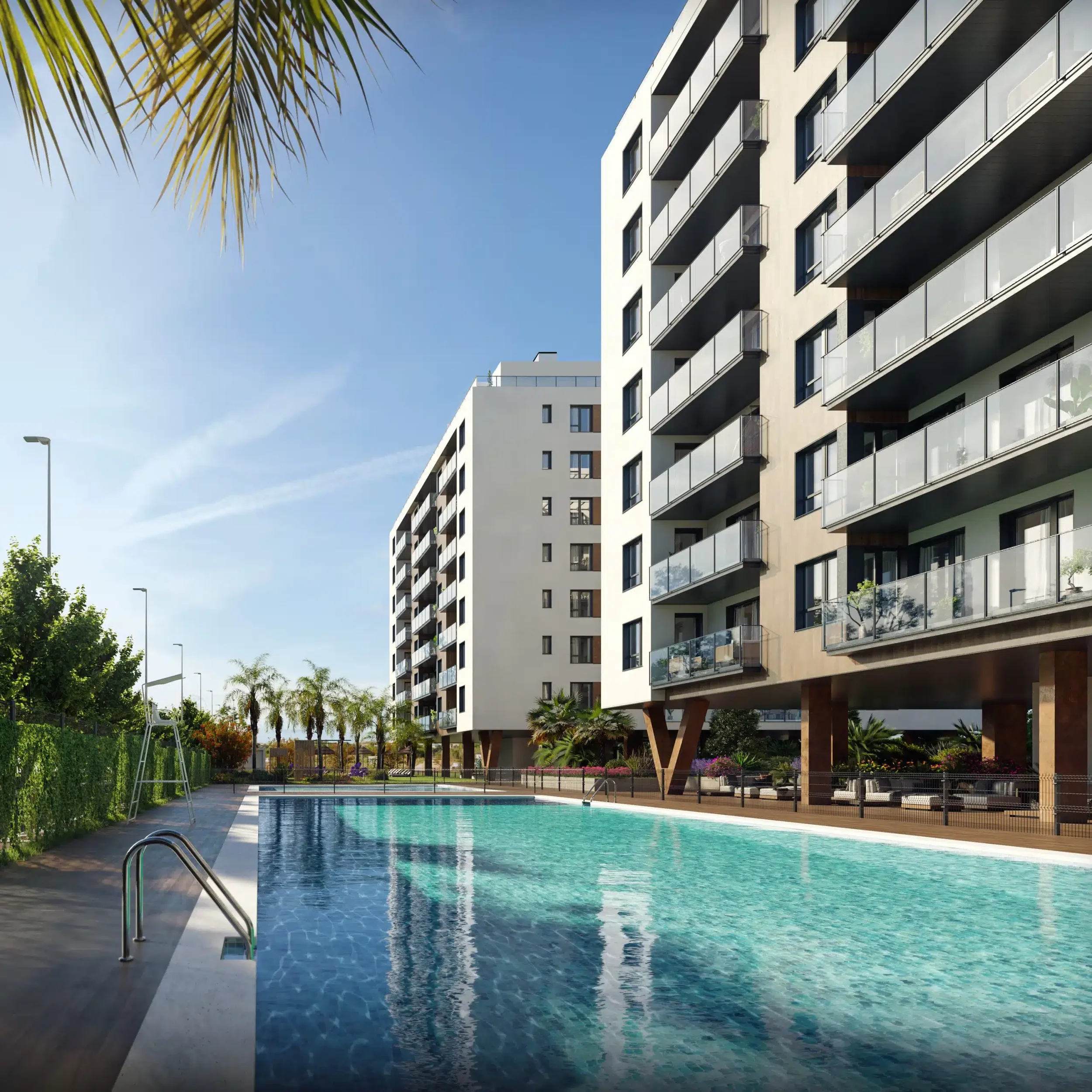 Modern apartment buildings with balconies overlooking a swimming pool and landscaped outdoor area on a sunny day.