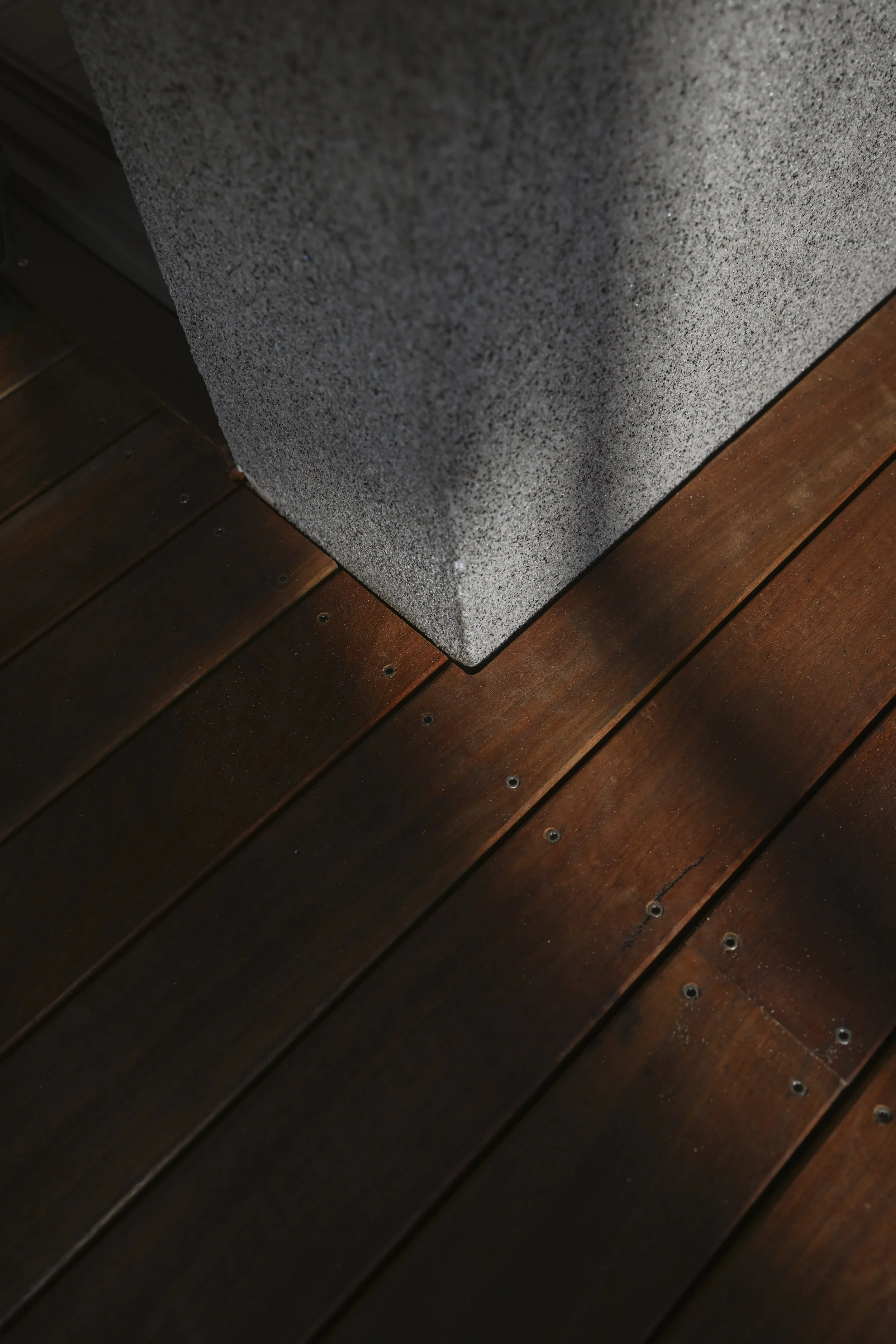 Close-up of a concrete block on a wooden deck.