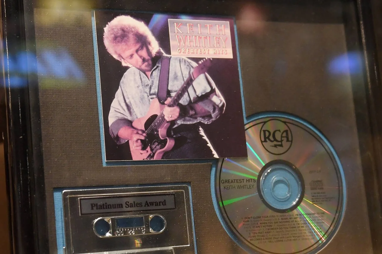 Keith Whitley's Greatest Hits album cover, a CD titled "Greatest Hits" by Keith Whitley with an award label reading "Platinum Sales Award."