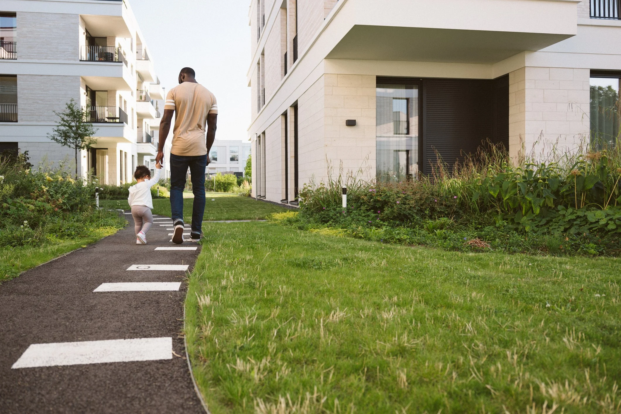 Man and child walking between buildings.