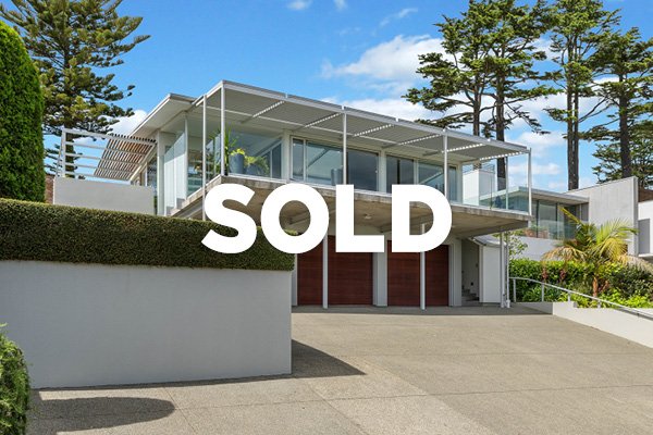 Modern two-story house with large glass windows, a balcony, and a 