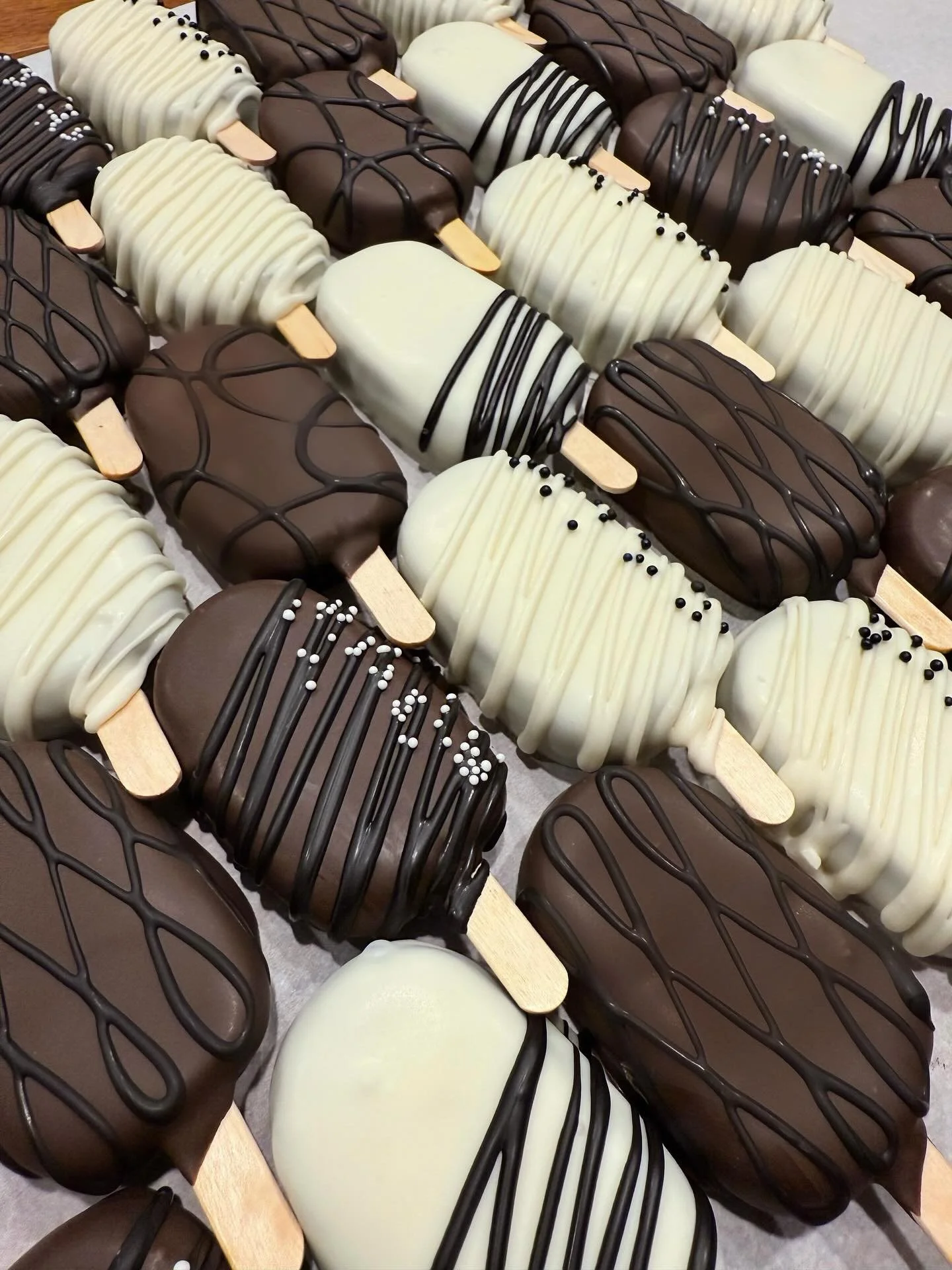 a recent order with an interesting request for black drizzle on white &amp; brown dipped pops. I love how they turned out! 
.
.