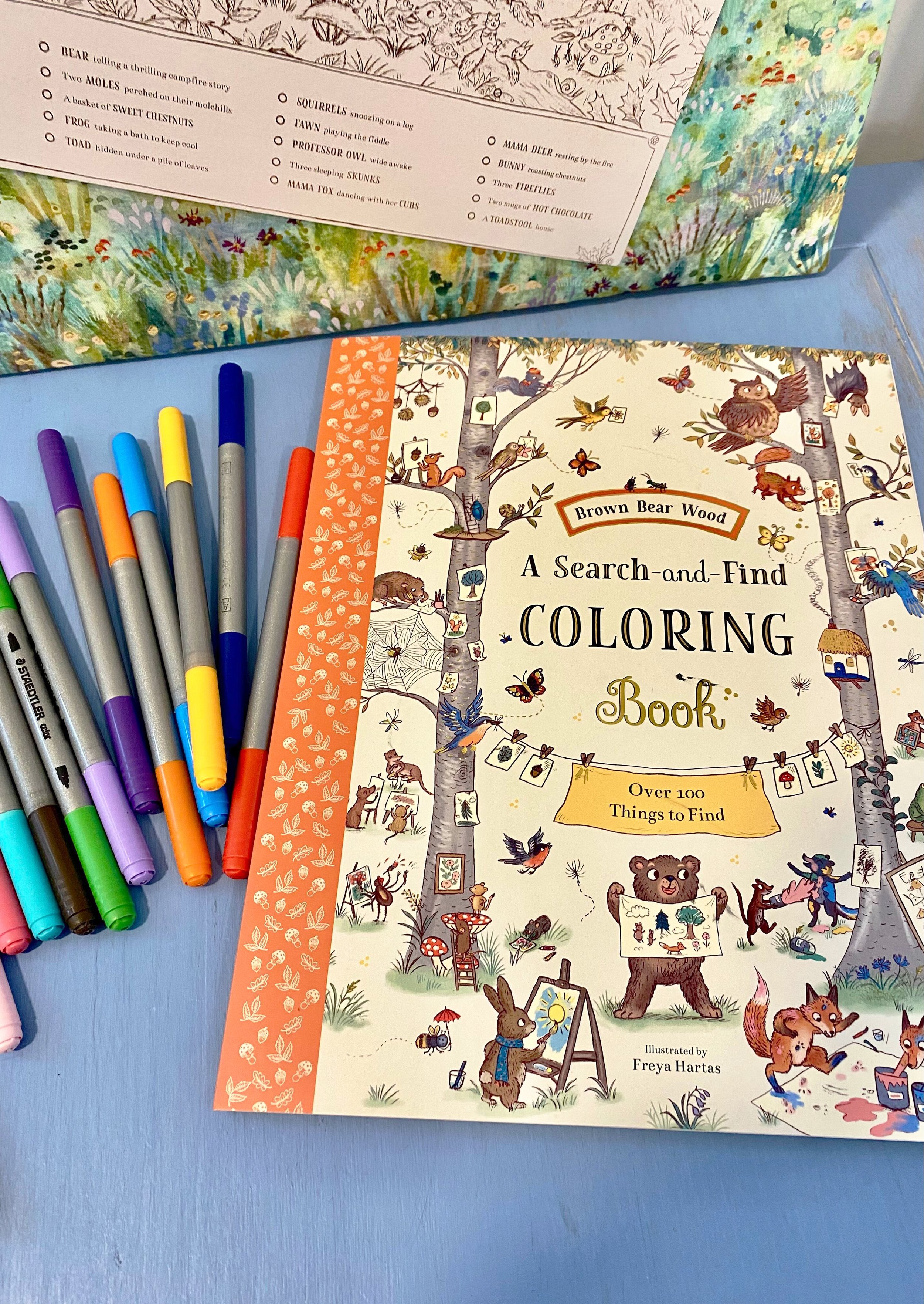 A children's colouring book on a table with markers.