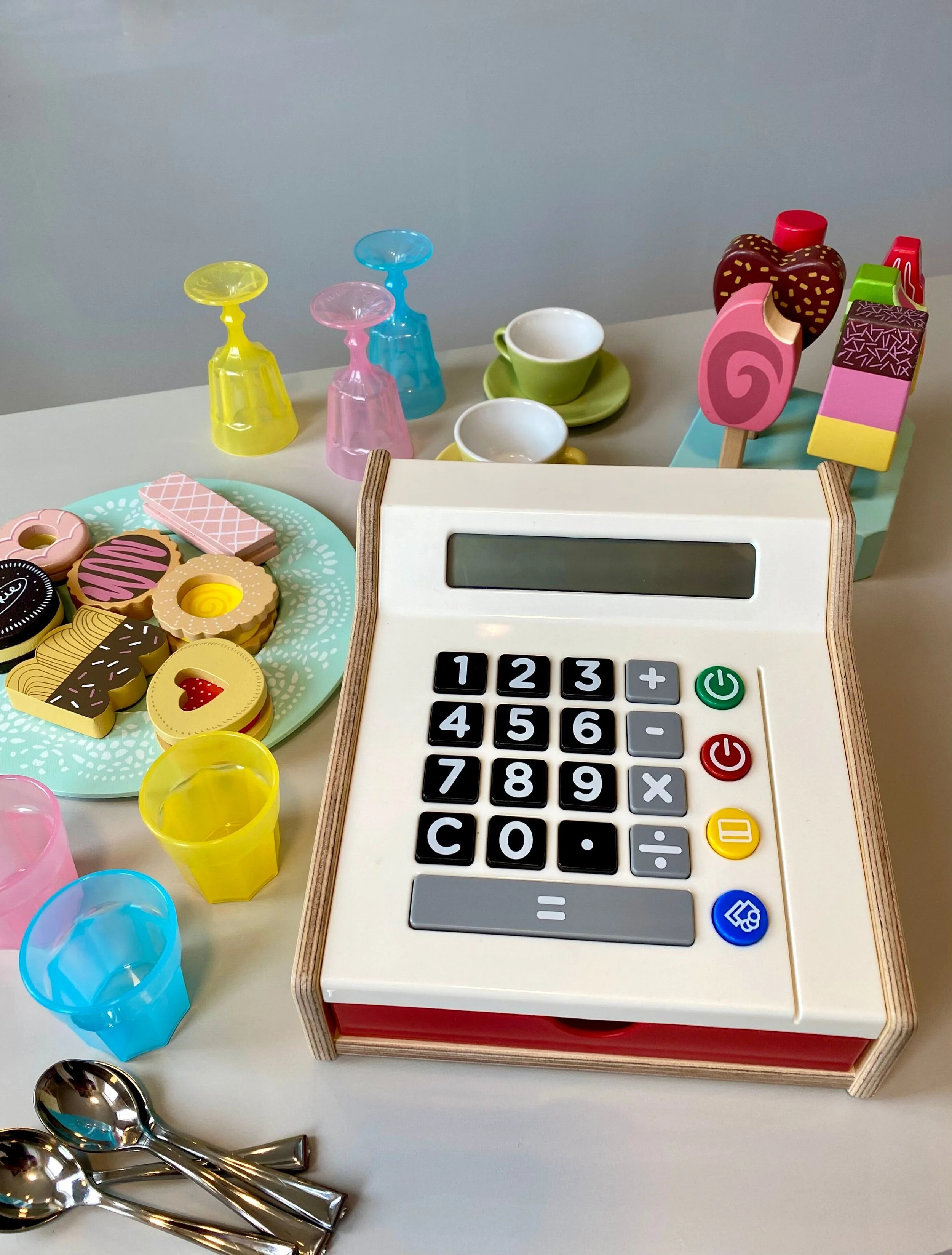 Toy cash register with pretend cookies and ice cream.