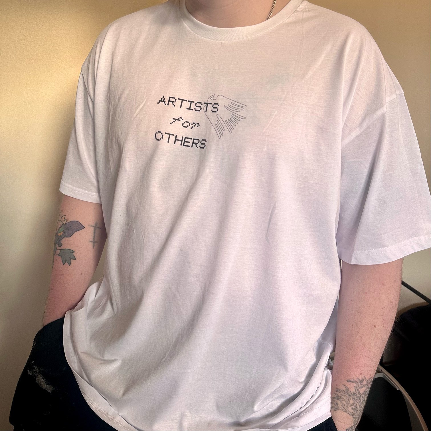 Black T short with small white text reading ARTISTS for OTHERS with bird logo