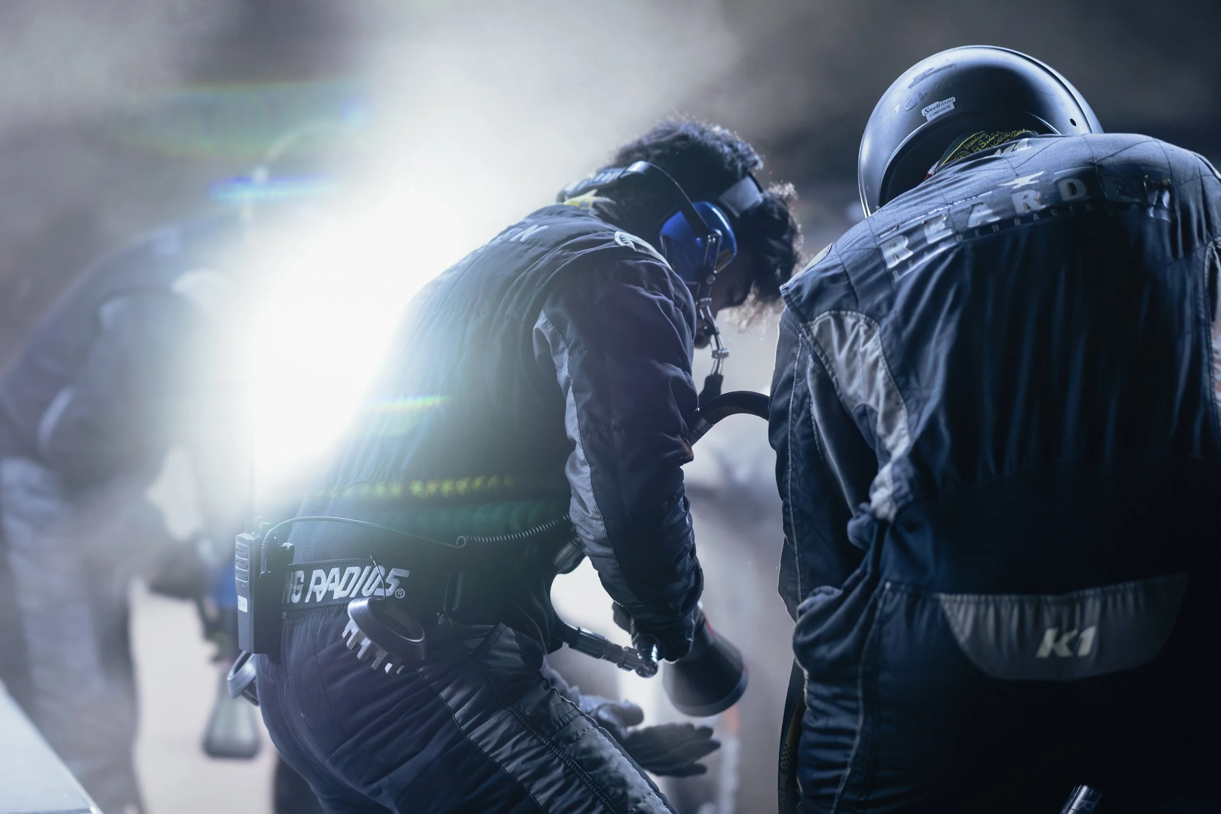 A race team crew member grabs his air gun to perform a tire change pit stop during an endurance race.