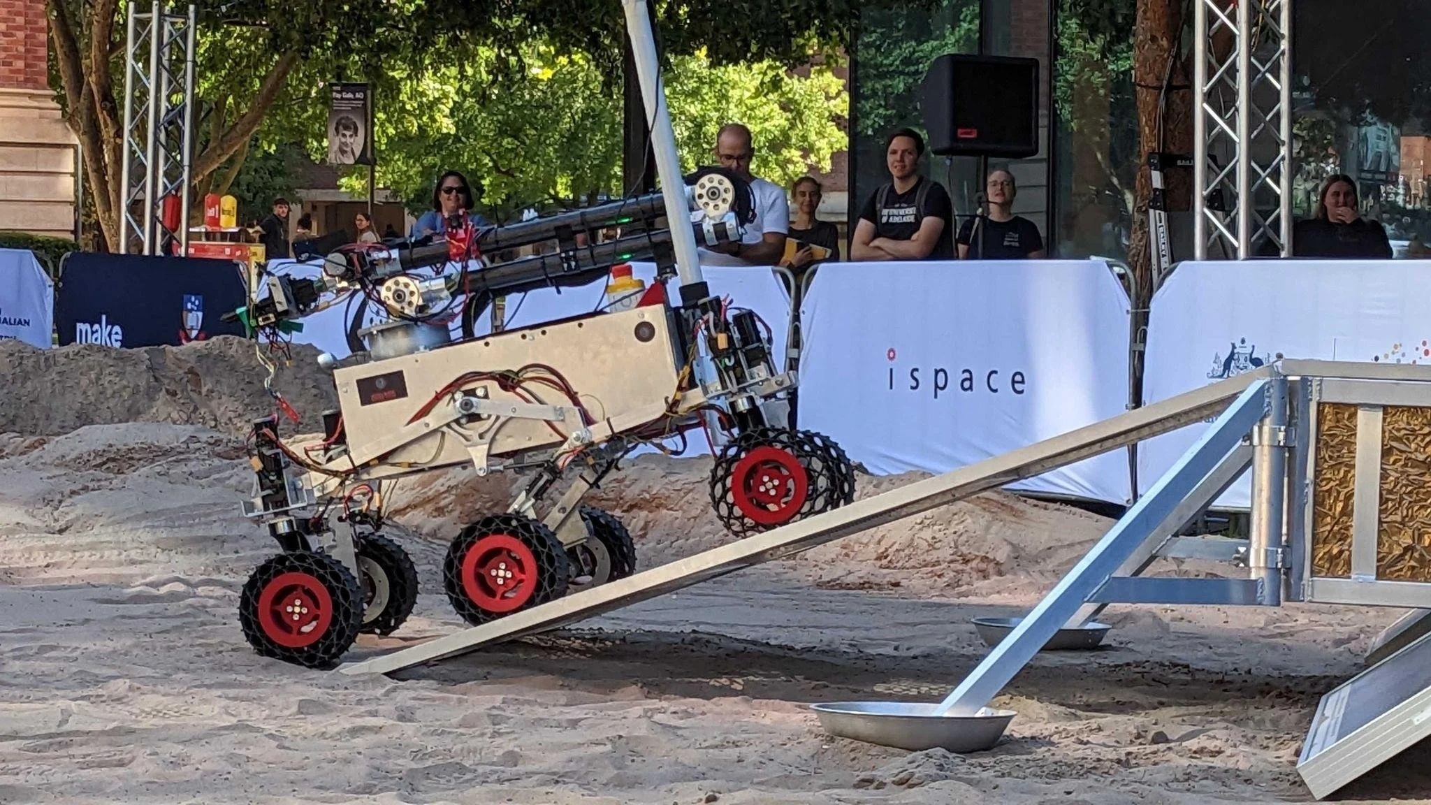 a rover with black-red wheels climbing up
