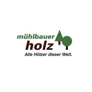 Logo for Mühlbauer Holz with green and brown text and a stylized tree icon, including the slogan 'Alle Hölzer dieser Welt'.