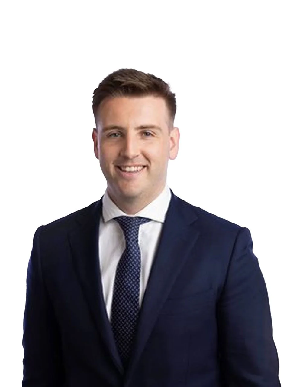 A young man in a navy blue suit, white shirt, and patterned tie, smiling against a plain white background.