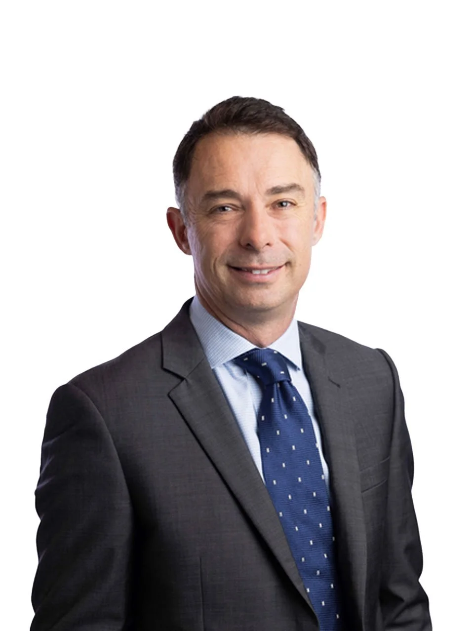 Chris Davies, a professional man in a dark suit, light blue shirt, and blue tie with small white patterns, smiling against a white background.