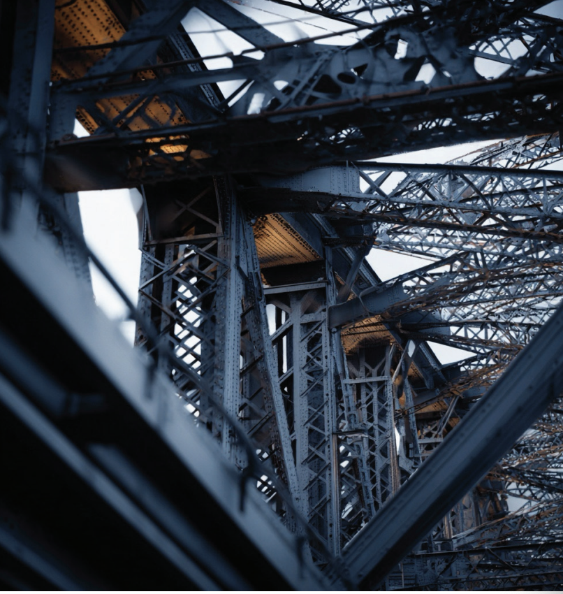 Close-up of the Eiffel Tower's intricate iron lattice structure from underneath.