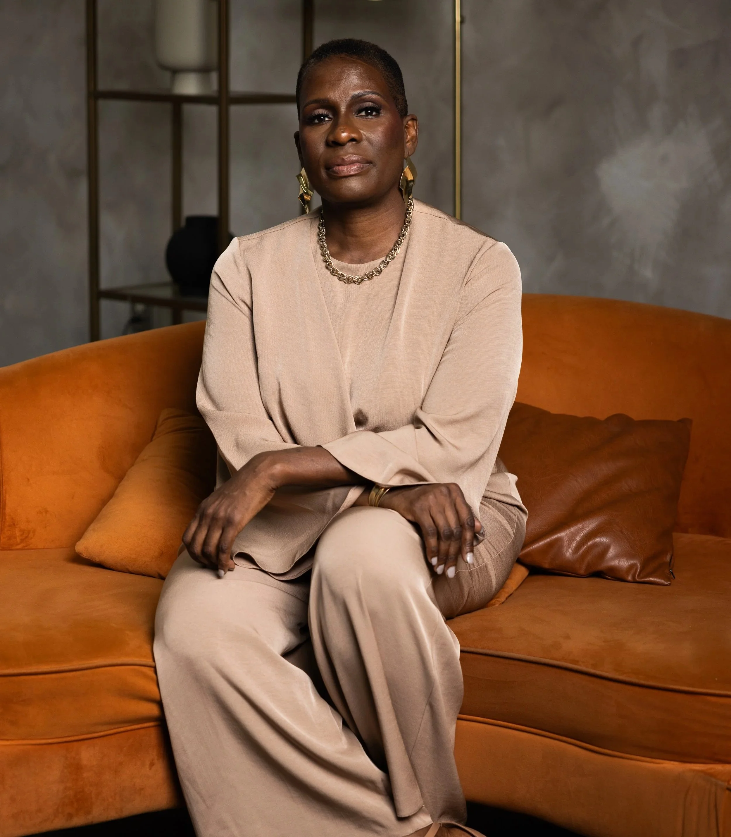 Leslie Marant speaker and strategist sitting on a tan couch