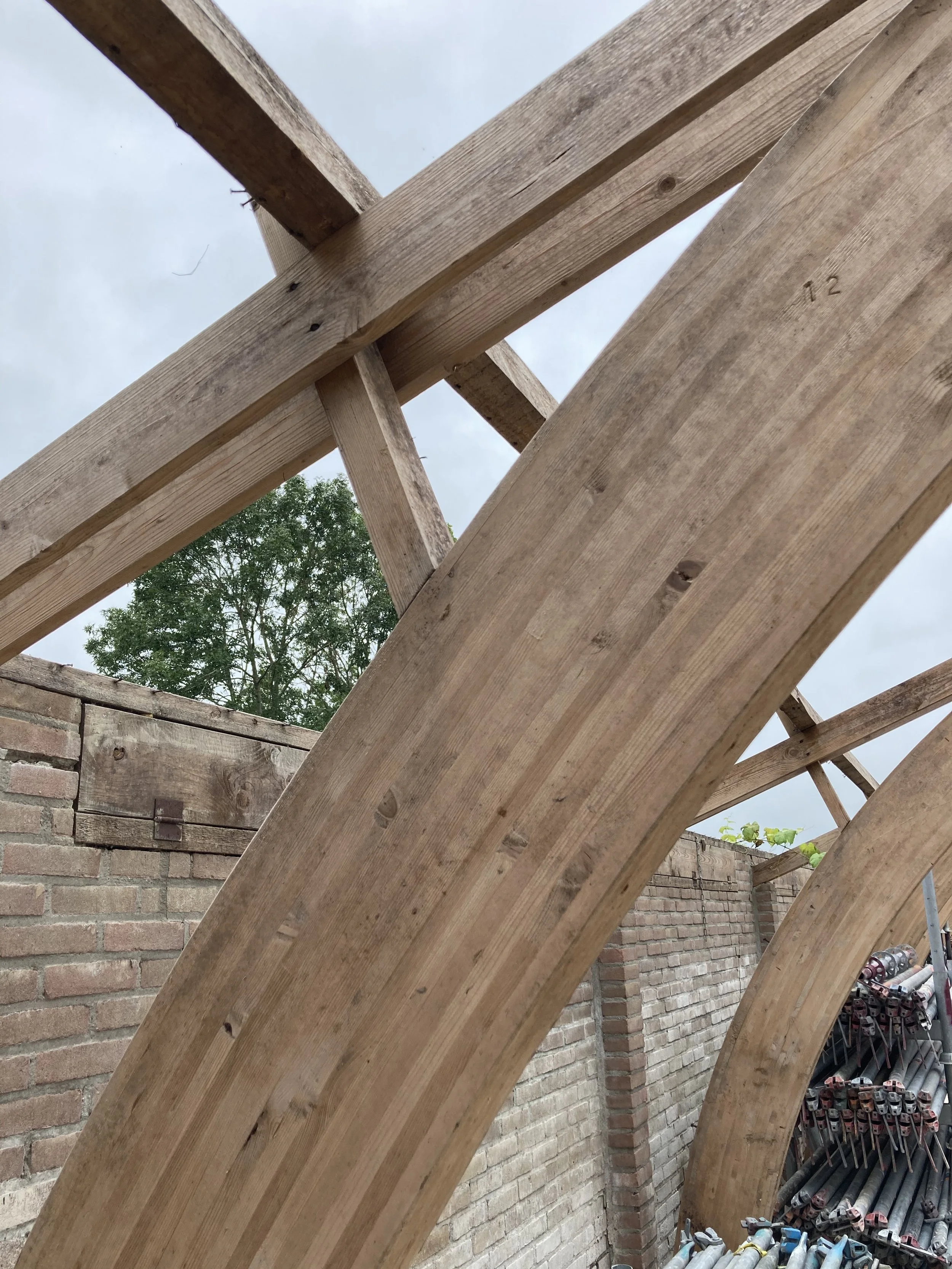 Detail foto van een houten draagconstructie, van een oude varkensstal, uit een oude boerderij, waar een nieuwe uitbreiding mee is gemaakt voor een restaurant.