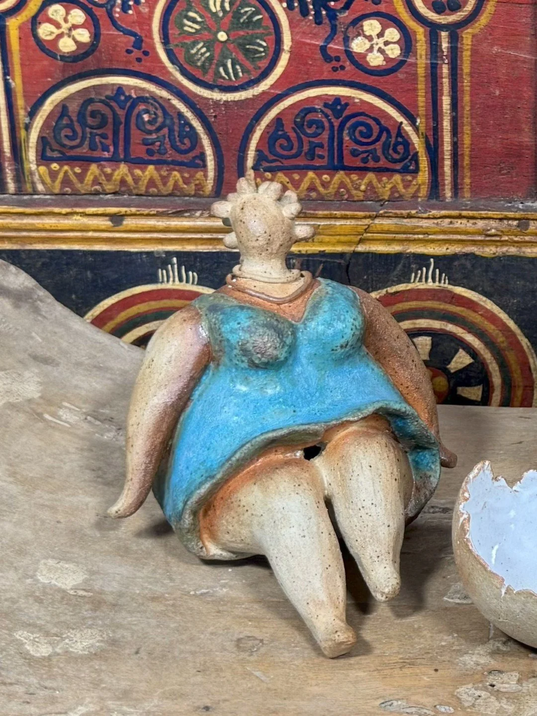 Sitting lady in a dress by ceramic Artist Nupur Narain DeTar, a beautiful handmade sculpture inspired by African art.