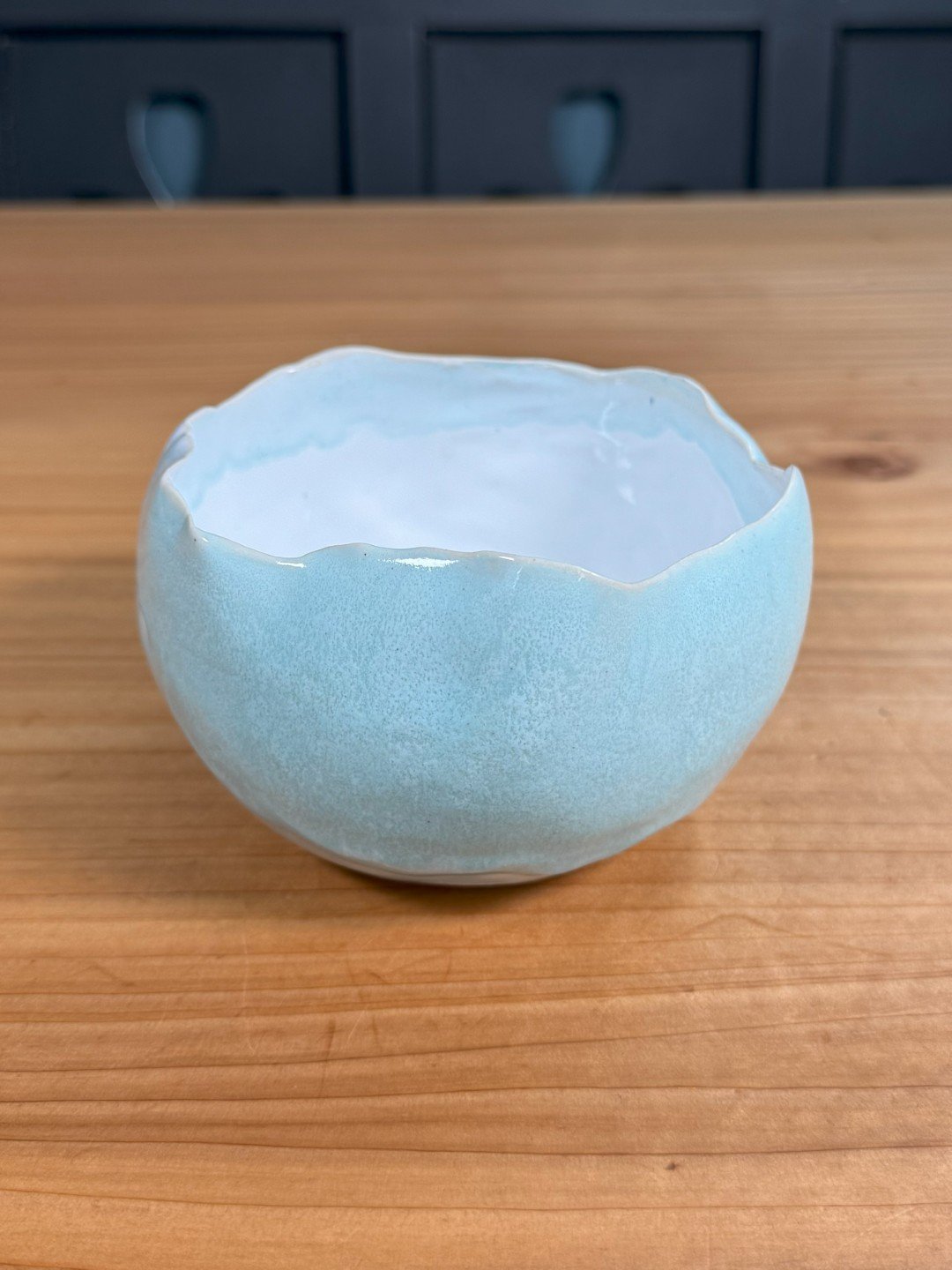 Unique medium raw-edged bowl by Artist Nupur Narain DeTar, hand-built with white glaze inside and copper blue outside.