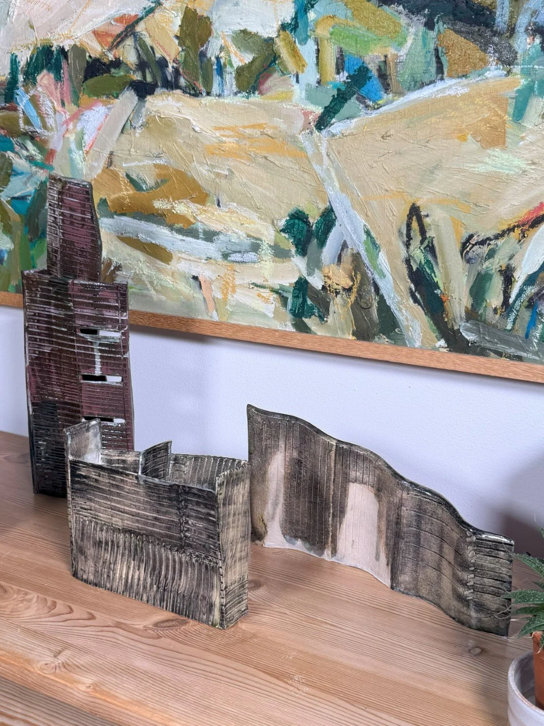 Rooftile fragment 2 by ceramic Artist Cristina Lorenzet displayed on table with other sculptures Rooftile and Skyline 3.