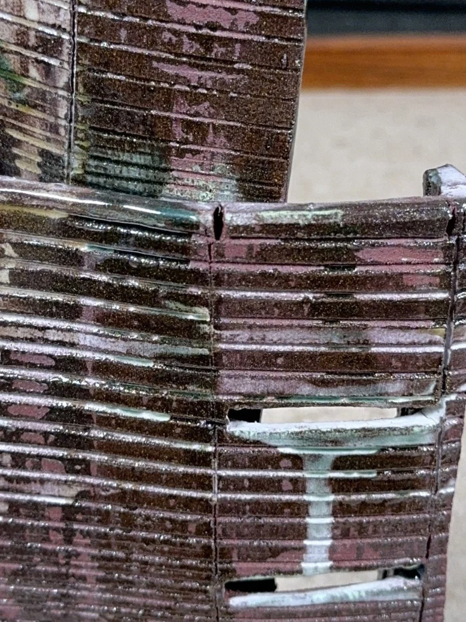 Close-up of Skyline 4 by ceramic Artist Cristina Lorenzet, a red stoneware sculpture decorated with white and green slips.