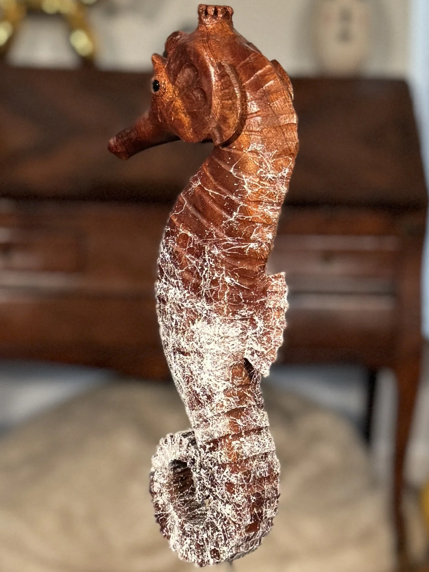 Side view of Skinny Seahorse by Julien Hipeau, a wooden sculpture carved from a reclaimed window sill.