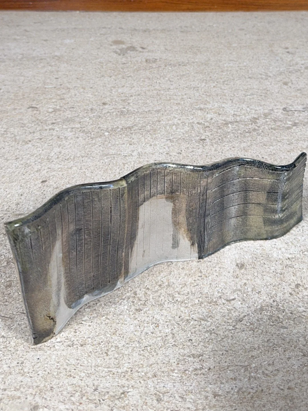 Angle view of Rooftile fragment 2 by ceramic Artist Cristina Lorenzet, a handmade undulating white stoneware sculpture.