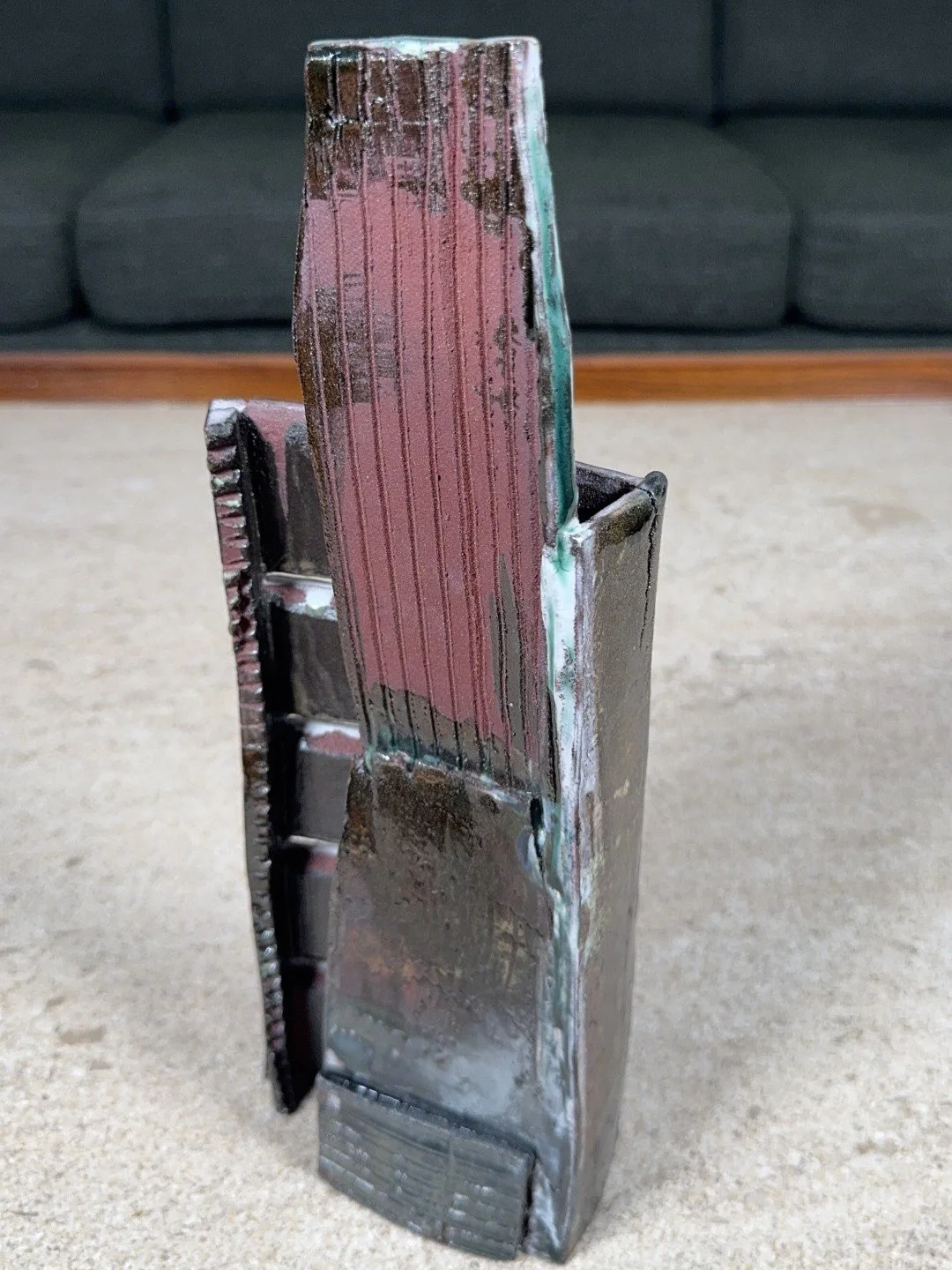 Back view of Skyline 4 by ceramic Artist Cristina Lorenzet, a red stoneware sculpture decorated with white and green slips.