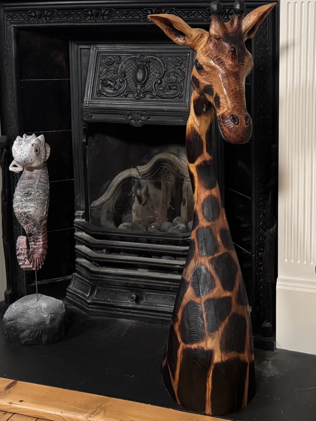 Seahorse sculpture by Artist Julien Hipeau, an original jesmonite artwork displayed next to a Giraffe sculpture.