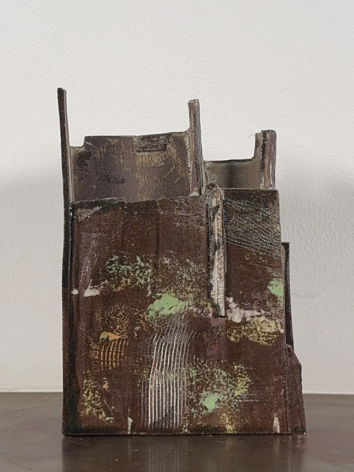 Front view of Skyline 2, a red stoneware sculpture by Artist Cristina Lorenzet decorated with white and green slips