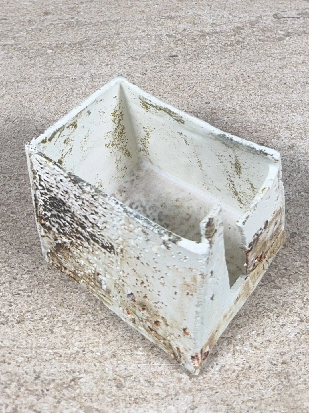 Patina on a building by ceramic Artist Cristina Lorenzet, white textured stoneware and porcelain sculpture, top side view.
