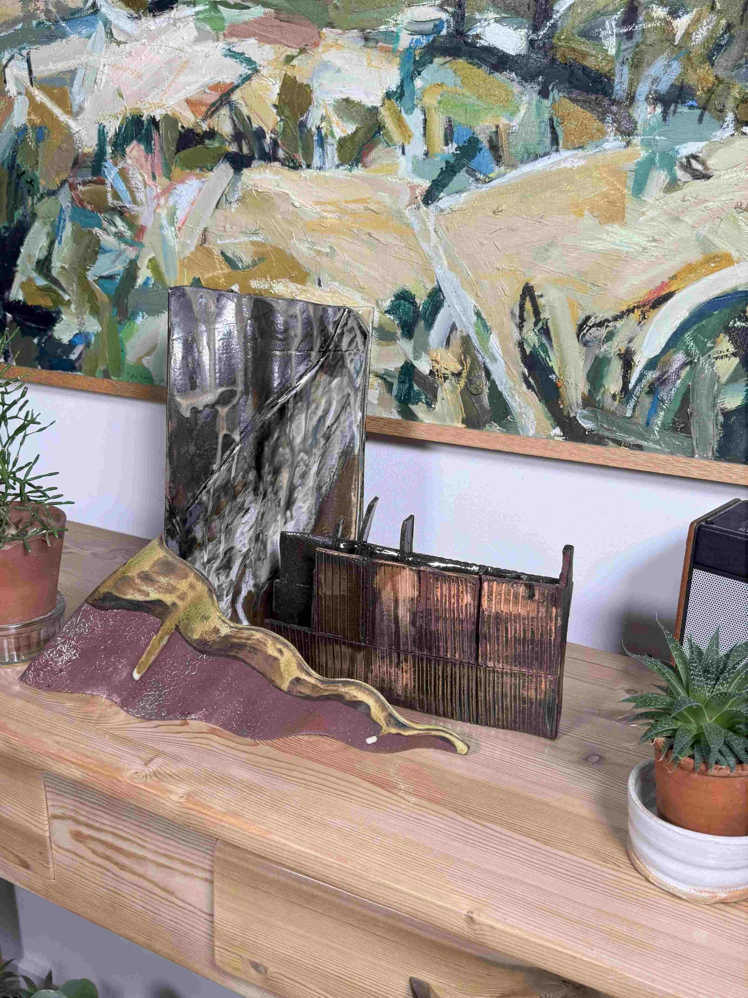 Skyline 1 red stoneware sculpture by ceramic Artist Cristina Lorenzet displayed on a side table with other artworks.