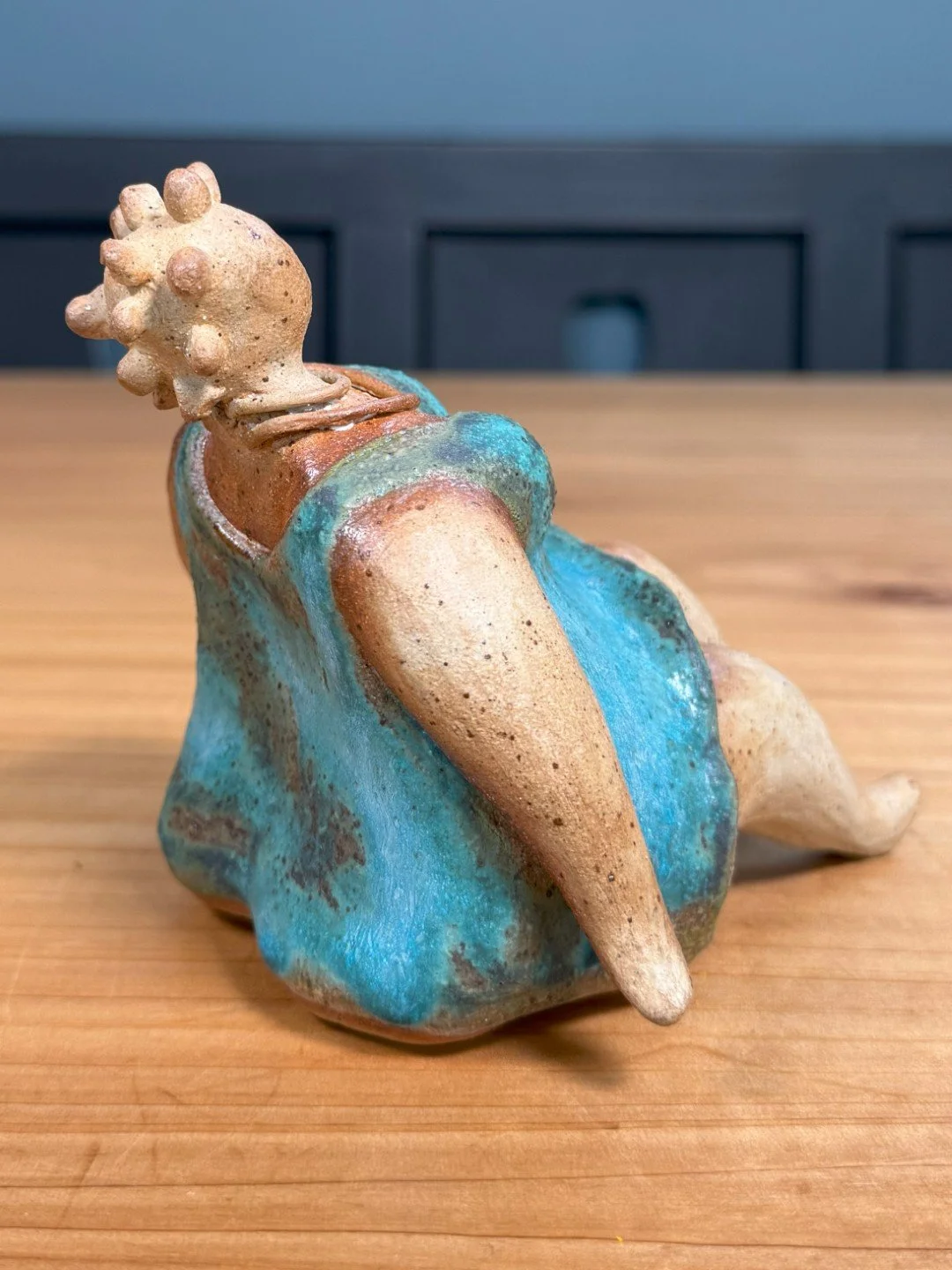 Sitting lady in a dress by ceramic Artist Nupur Narain DeTar, a beautiful handmade sculpture of the female form.