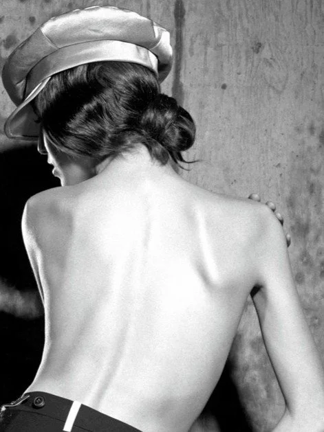 Vivienne and the mirror, a photograph by Carlos Lumiere, from a shoot for Vivienne Westwood Jewellery, closeup of the model's back.