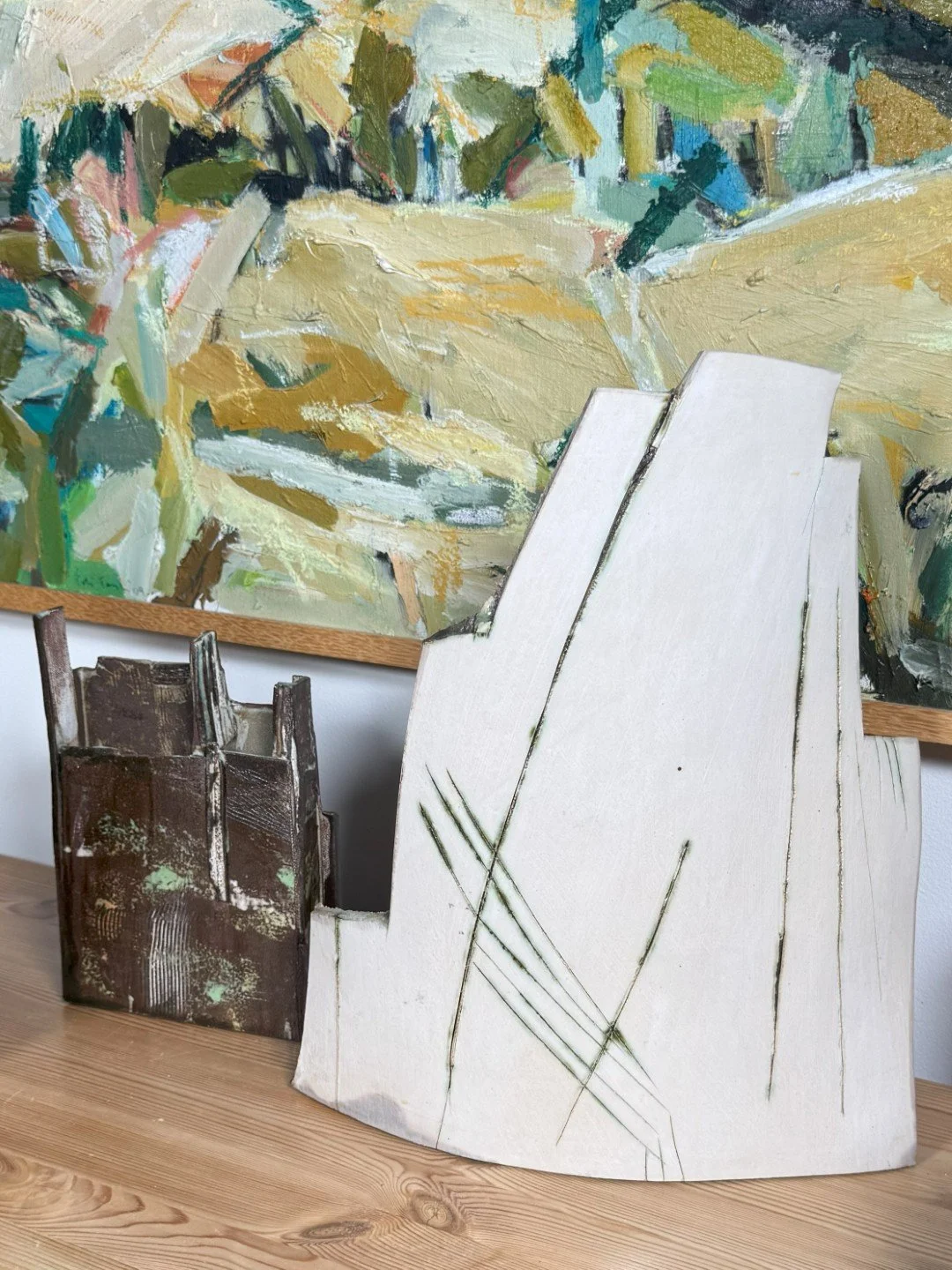 London Façade 1 by ceramic Artist Cristina Lorenzet, a white stoneware sculpture displayed with other artwork on side table.