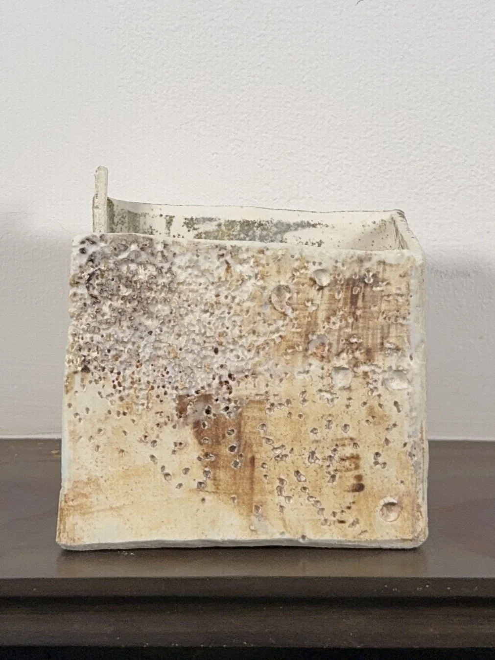Patina on a building by ceramic Artist Cristina Lorenzet, a textured stoneware and porcelain sculpture, side view.