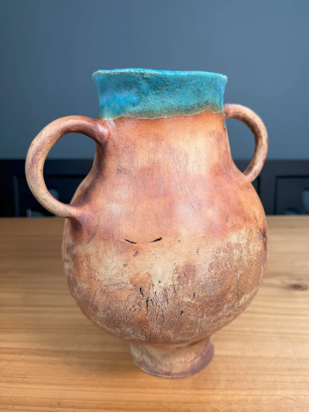 Back view of large handbuilt ceramic vase by Artist Nupur Narain DeTar, with turquoise glaze inside and iron oxide outside.