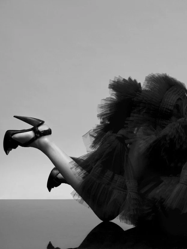 Miaouu, a photograph by Carlos Lumiere, left side of the image, a model is styled in a dramatic black dress and spiked heels.