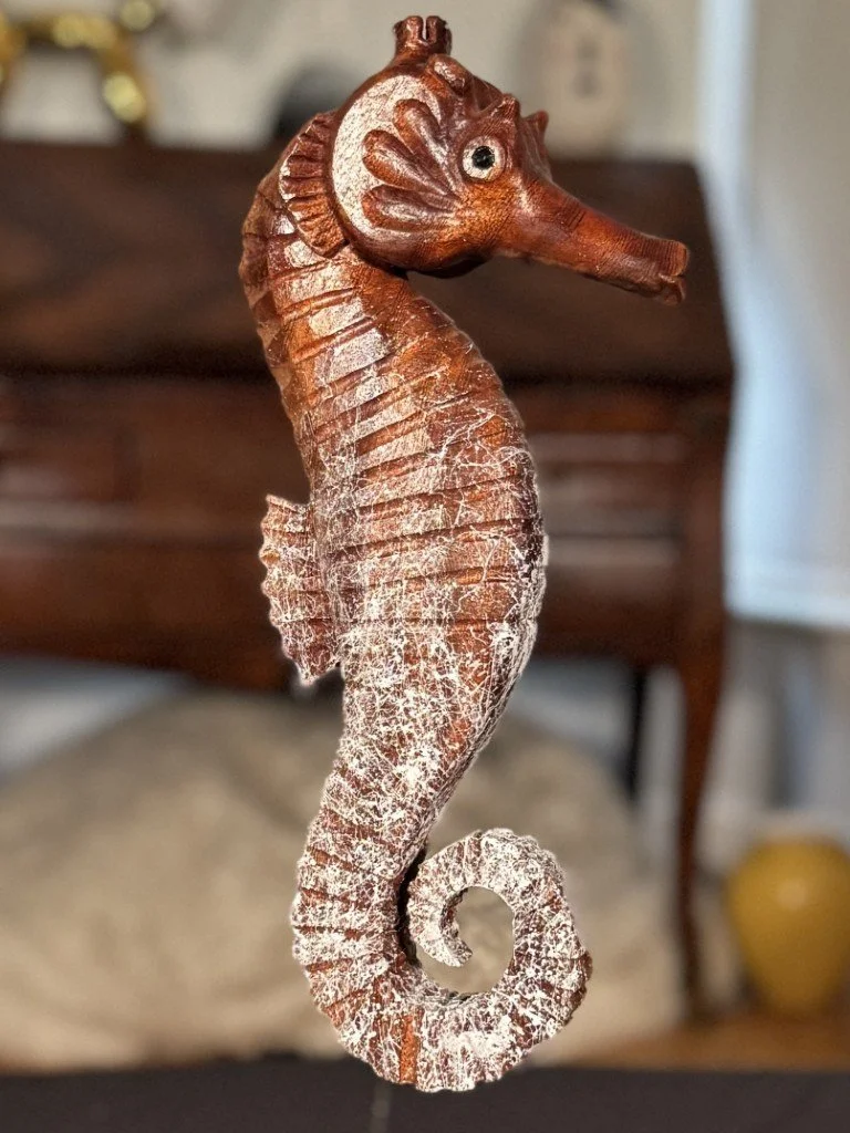 Skinny Seahorse by Julien Hipeau, a wooden sculpture with the tail painted and the body displaying a natural wood finish.