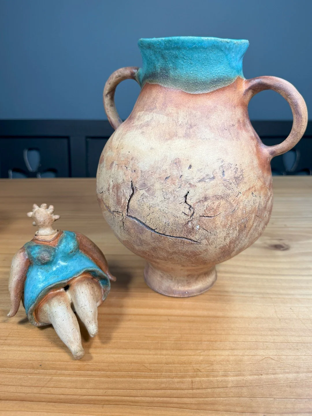 Sitting lady in a dress by ceramic Artist Nupur Narain DeTar, a beautiful sculpture displayed with large handbuilt vase.